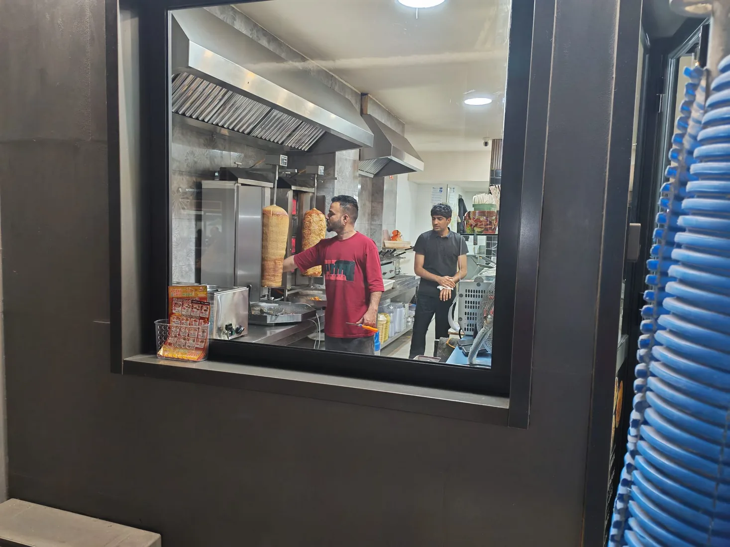 Dos trabajadores preparando pedidos en la cocina de Kebab & Grill House