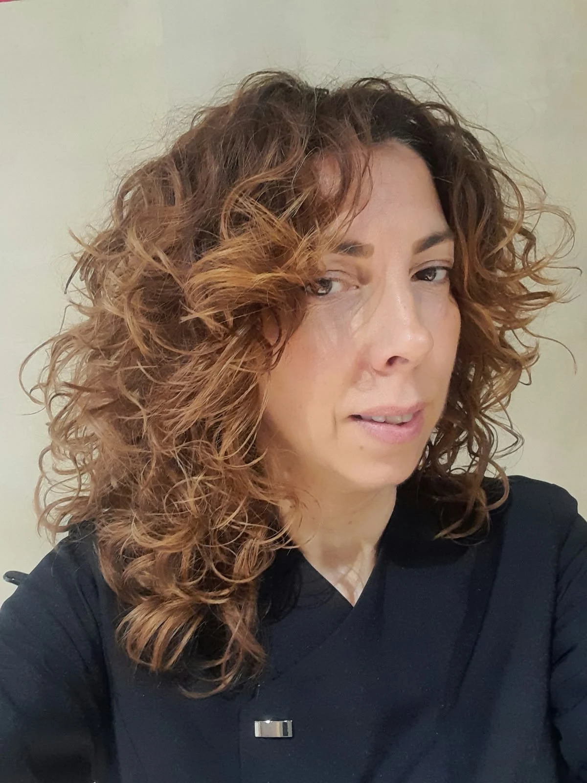 Profesional del salón KizCurly, con cabello rizado